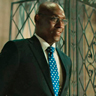 Lance Reddick en el papel de Charon